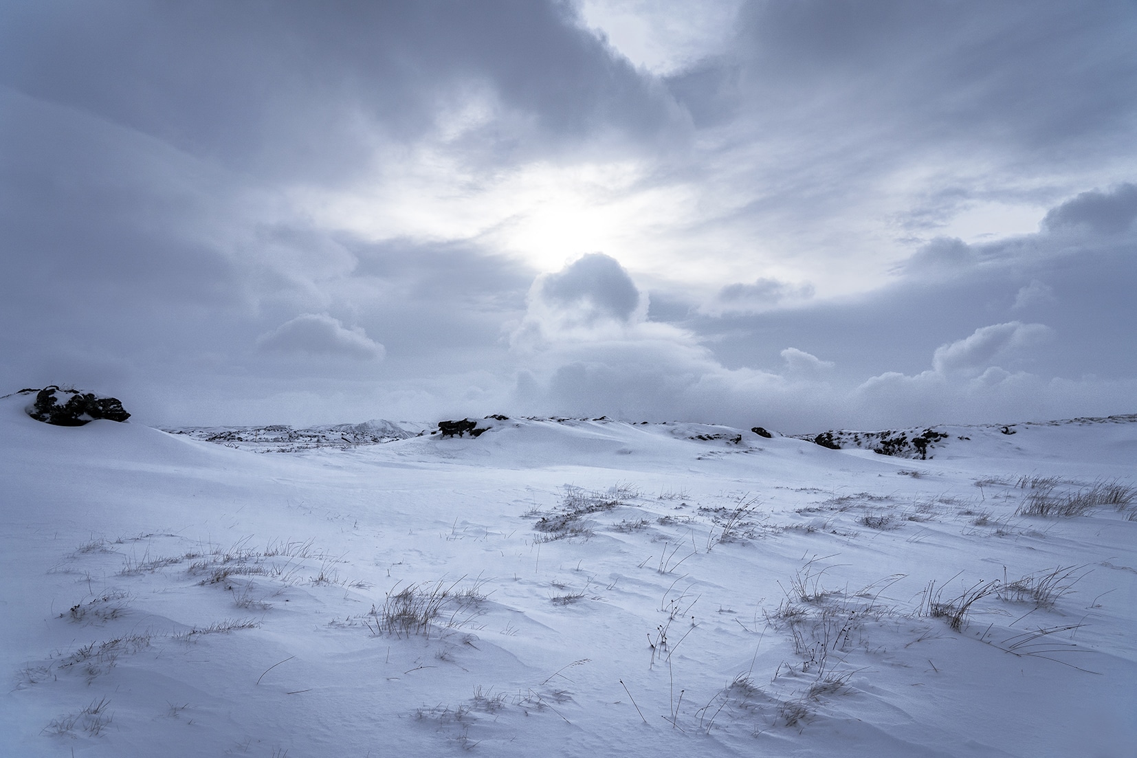 Mývatn lac neige nuage noirs rayon de soleil Islande en hiver