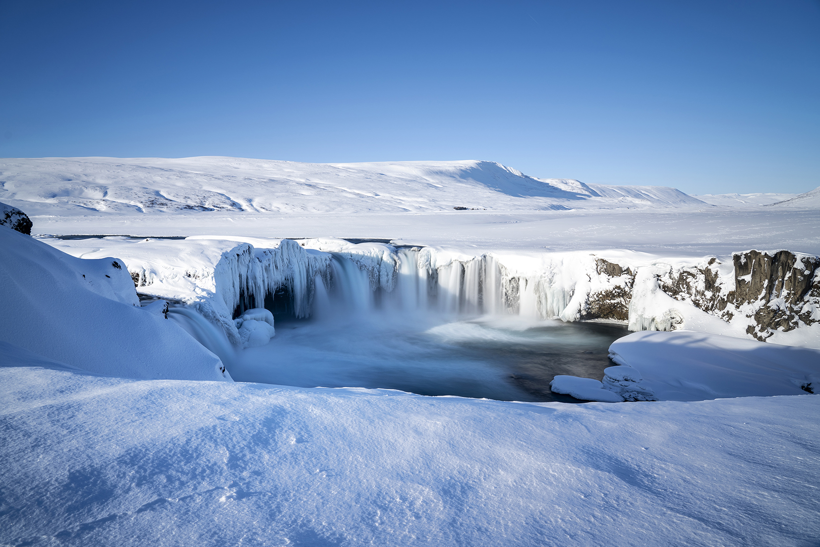 Islande du Nord Goðafoss vue d'ensemble cascade féerique neige eau stalactites ciel bleu