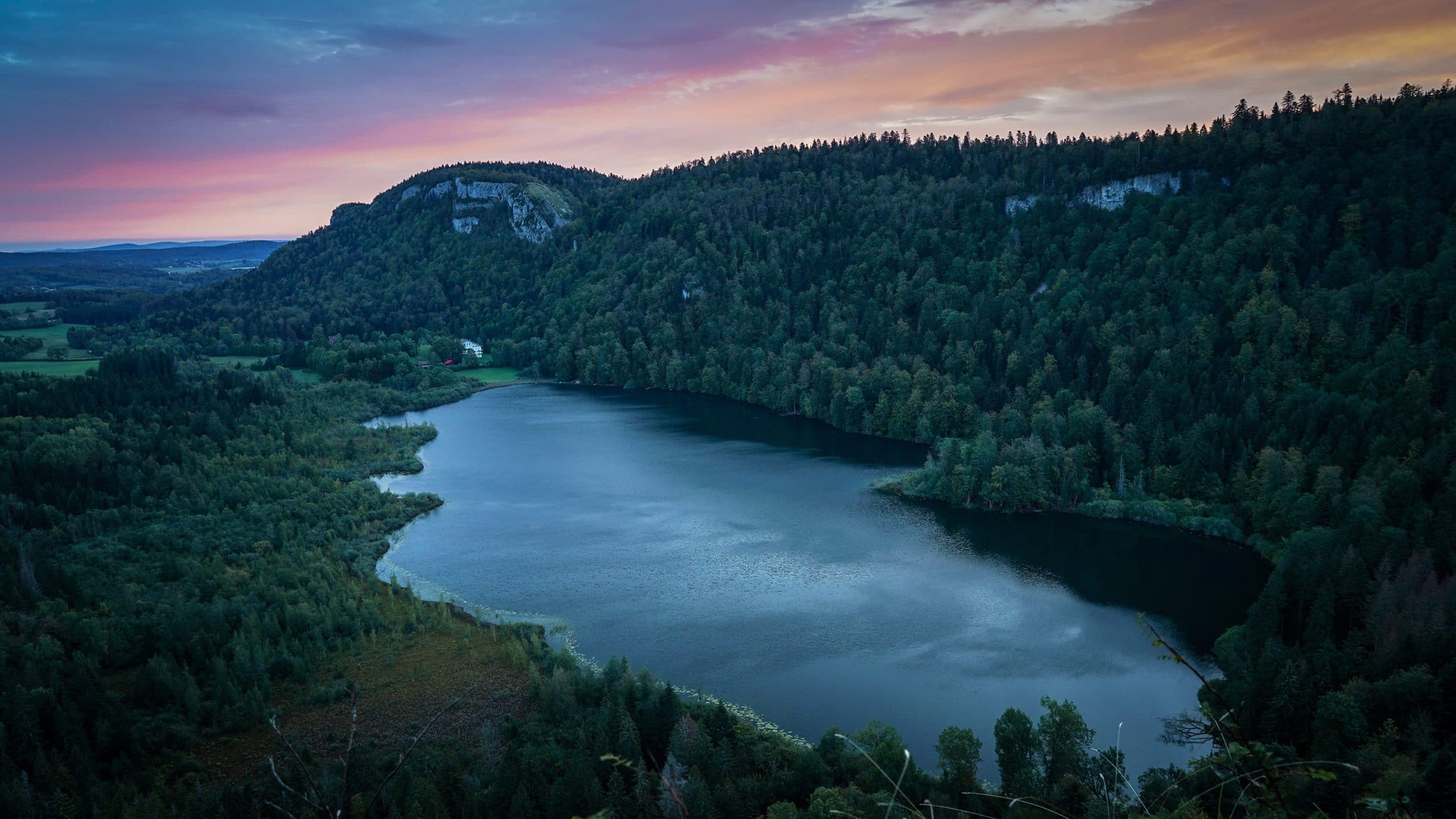 lac de Bonlieu lever de soleil eau nuages roses oranges Jura sapins montagnes