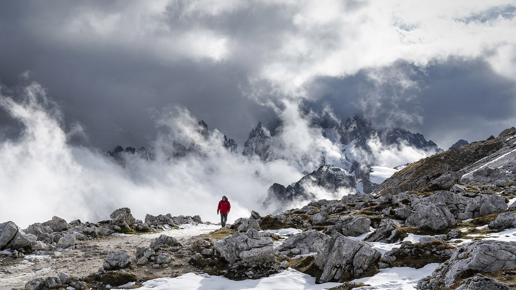Dolomites Italie nuages lumière homme manteau rouge